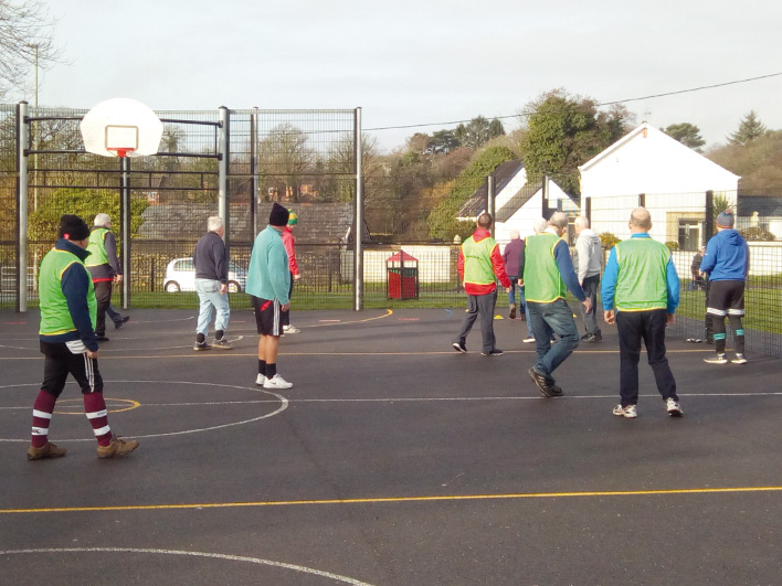 Over 50s playing walking rugby on a basket ball court