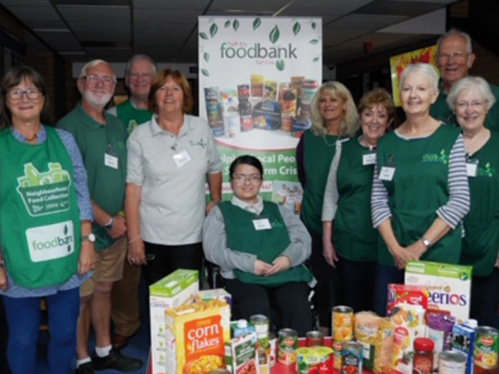 Volunteers gathered around food donated to foodbank